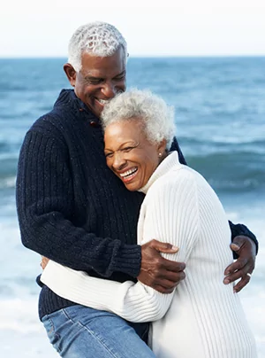 A couple embraces after getting dentures