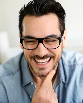 A man with dental crowns smiles for the camera